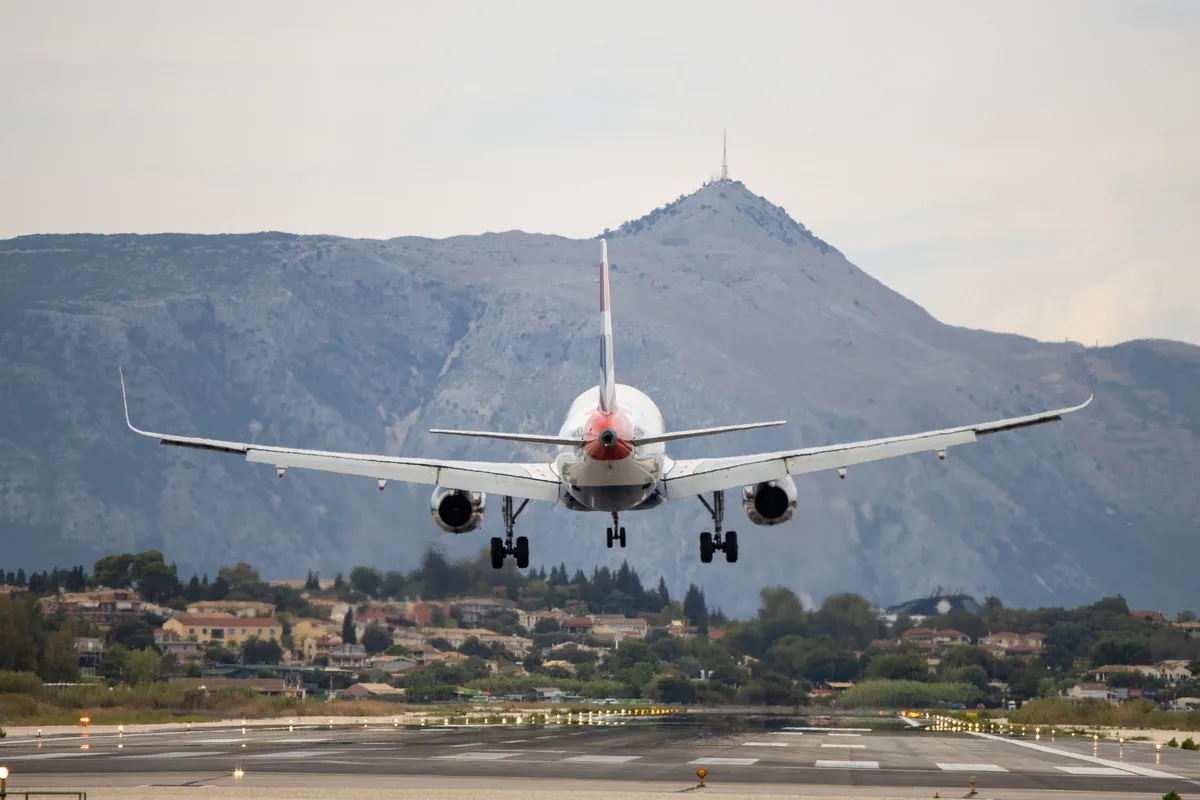 Passenger plane approaching the runway at Corfu with mountains behind