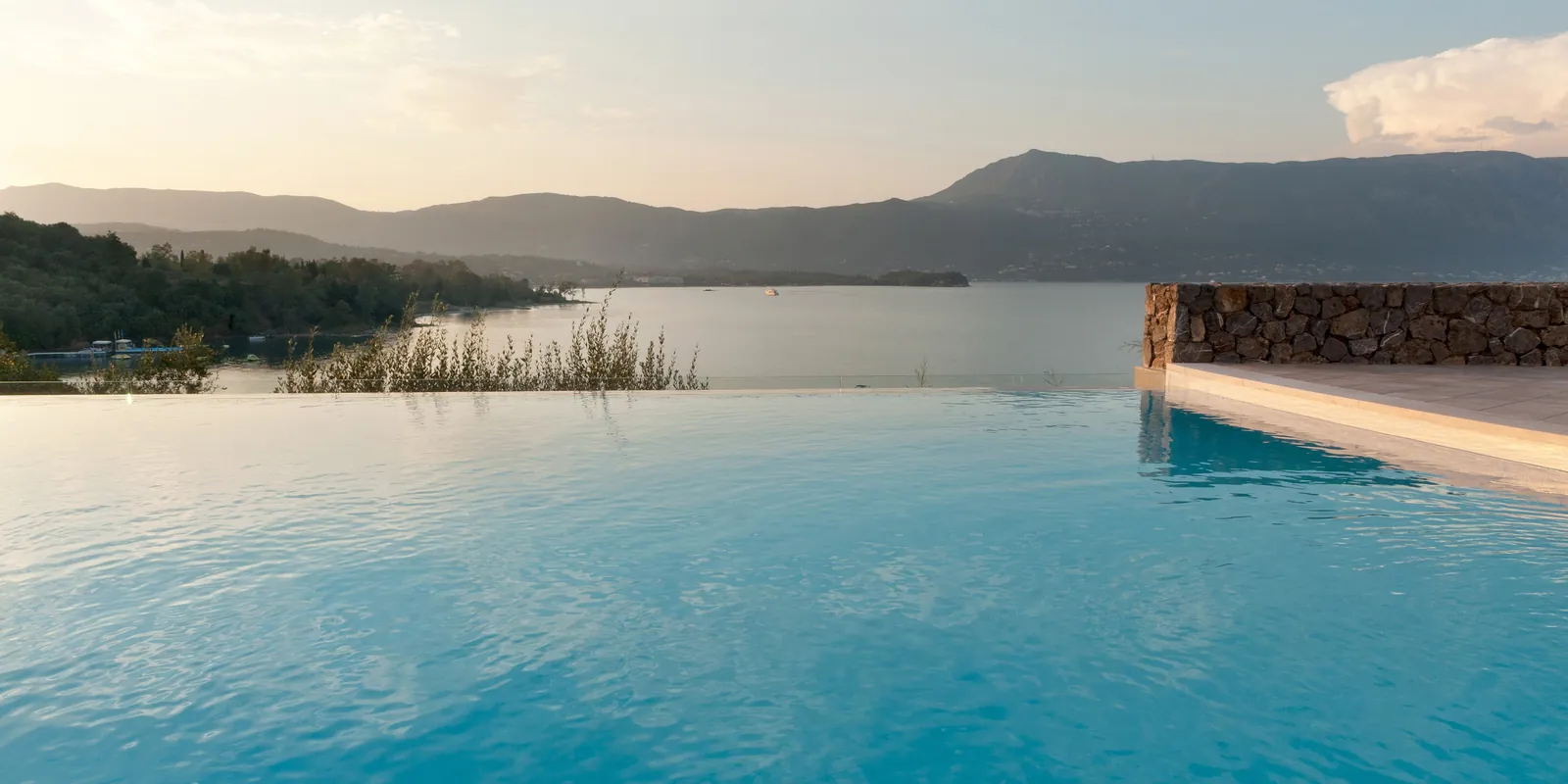 Infinity pool at sunset at a beachfront villa in Kommeno, Corfu