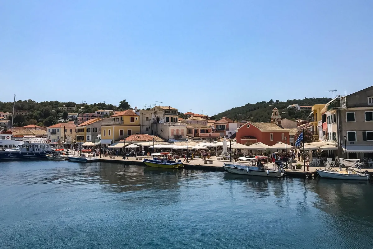 Waterfront village on Paxos with pastel houses and moored boats